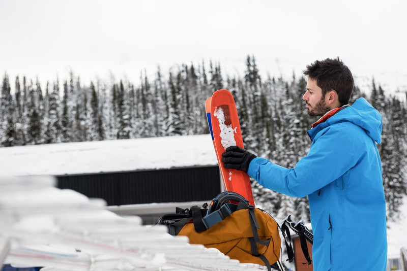 skier holding skies on the snowy mountains JTZBX6G